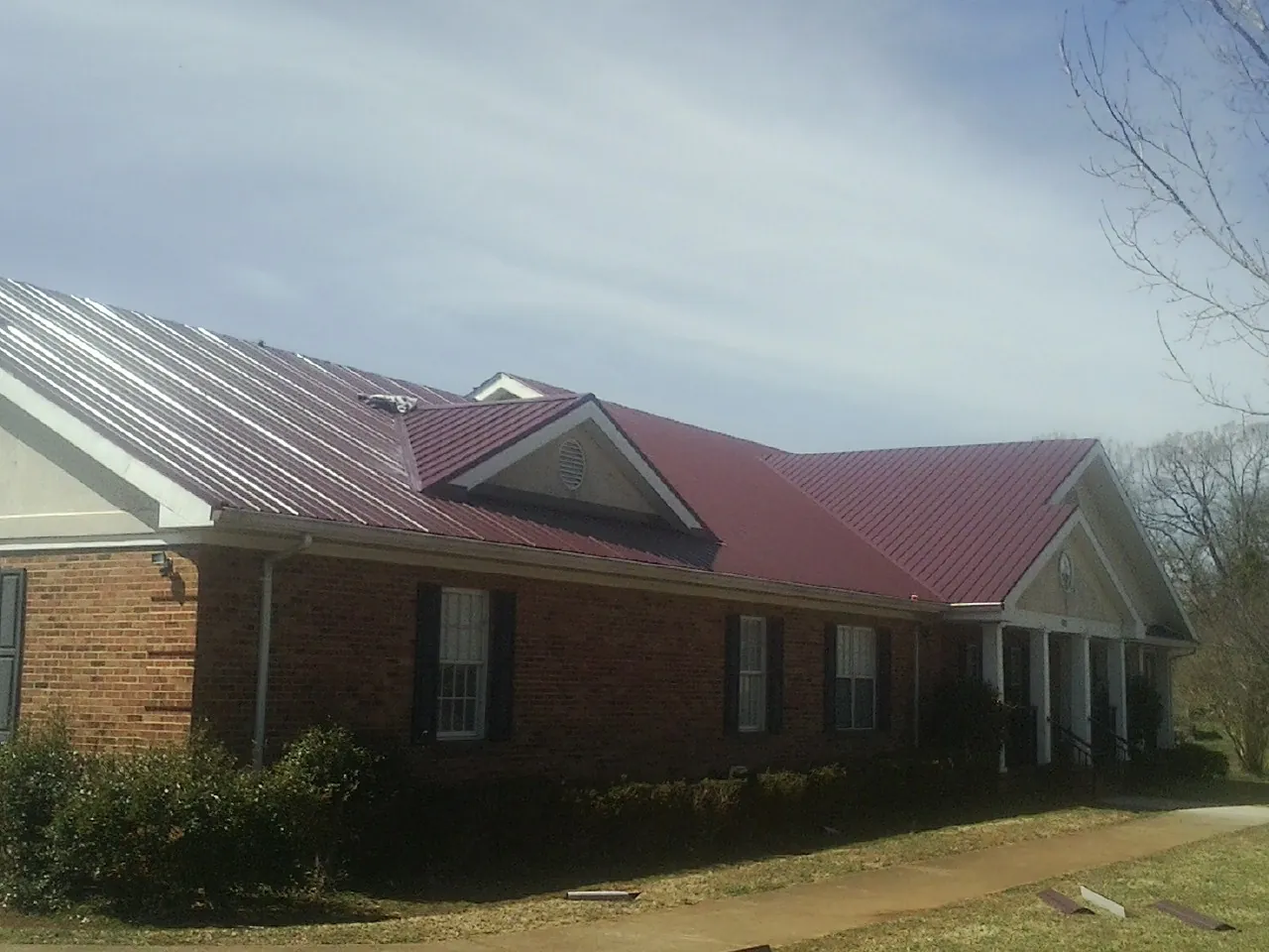 Red metal roof with gabled entries on a long brick building in Mayetta